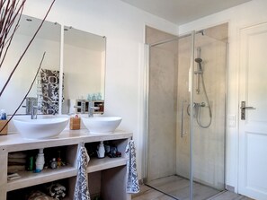 Een bad/douchecombinatie, een haardroger, handdoeken, zeep