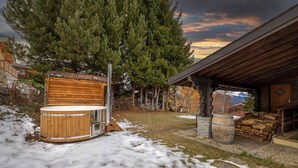 Een houten chalet met een jacuzzi, een sauna en een stenen openhaard.