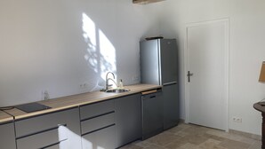 Moderni keittiö, jossa on sisäänrakennettu astianpesukone, hana ja allas sekä työtaso.