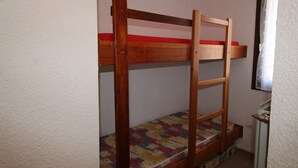 A bunk bed with a wooden frame and a colorful mattress.