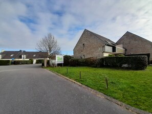 Stunning stone building with a pitched roof, set amidst a beautifully manicured lawn.