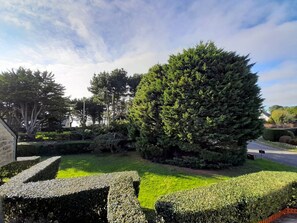 Stroll through the serene garden, surrounded by lush trees and shrubs, and take a seat on the inviting bench.