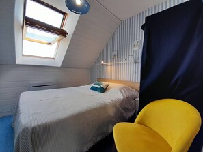 Cozy retreat with a single bed, window, and seating area.