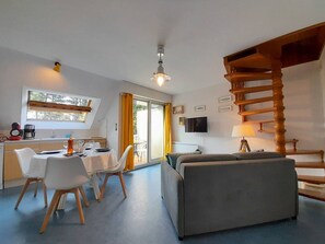 Cozy living space with a dining area, sofa, and staircase, perfect for relaxing and enjoying meals together.