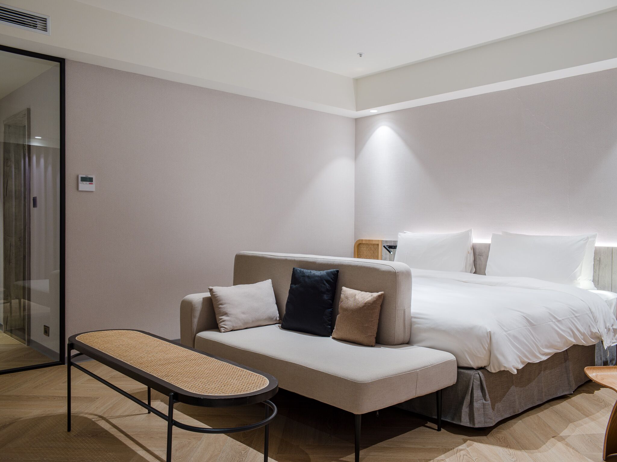 A modern hotel room with a bed, a sofa, and a small table.