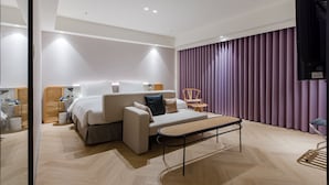 A modern hotel room with a bed, sofa, and a small table. - DAHU Park Hotel (Taipei)