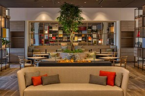 Een modern interieur met een centraal zithoek, een gashaard en een bar met planken.