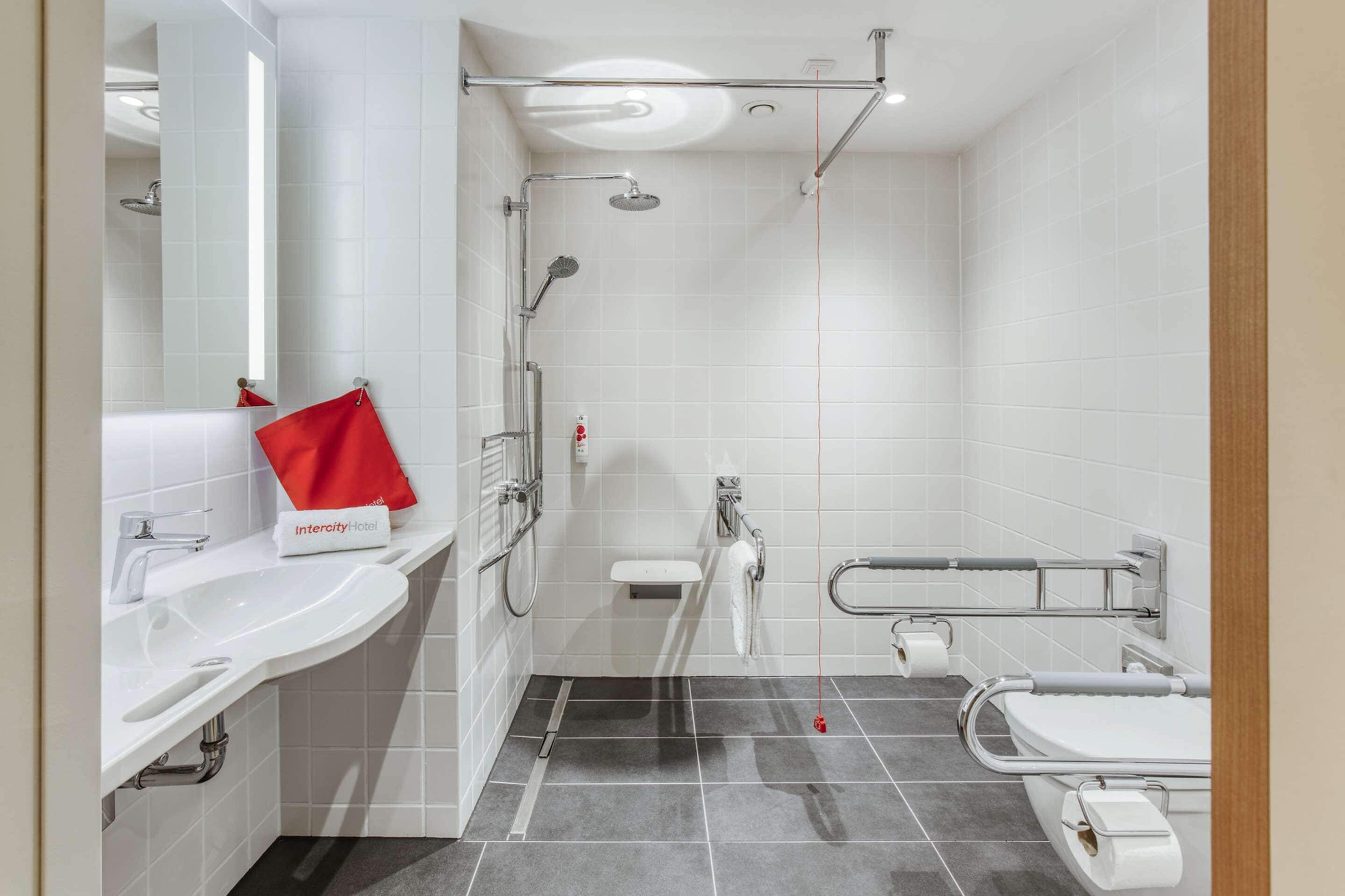 A modern bathroom with a shower, toilet, and sink.