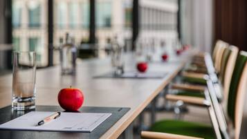 Una mesa de conferencias con un documento, un bolígrafo y una manzana.