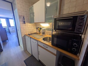 A compact kitchen with a microwave, oven, and sink. - Functional studio at the foot of the slopes, Mont Blanc view (Plagne Aime 2000)