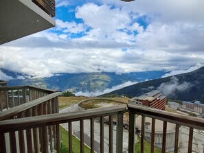 A view from a balcony overlooking a mountainous landscape with a road and buildings in the foreground. - Functional studio at the foot of the slopes, Mont Blanc view (Plagne Aime 2000)