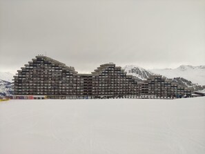 A multi-story hotel with a modern architectural design, featuring balconies and a flat roof.