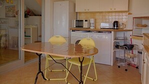 A compact kitchen with a dining table, chairs, a microwave, a coffee maker, and a dishwasher. - Charming Villa w/ Pool, Tennis, A/C, Near Beach in Porticcio - Sleeps 6 (Porticcio)