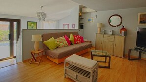 A living room with a sofa, a wooden bench, a glass coffee table, a television, and a cabinet. - Charming Villa w/ Pool, Tennis, A/C, Near Beach in Porticcio - Sleeps 6 (Porticcio)