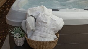 Ein Whirlpool mit Handtuch und einer kleinen Topfpflanze daneben.