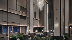 A modern hotel lobby with a central seating area, a decorative water feature, and a large chandelier. - Hualuxe Kunshan Huaqiao (Suzhou)