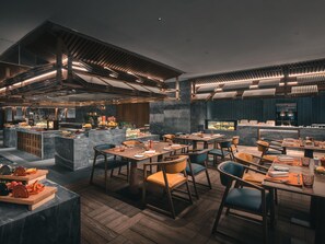 A modern restaurant with wooden flooring, marble countertops, and a variety of seating options including tables and chairs.