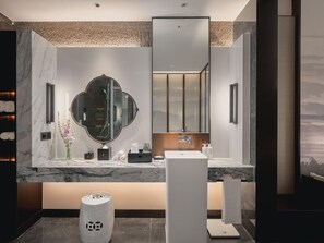 Un baño moderno con tocador de mármol, un espejo grande, un perchero y una balanza.
