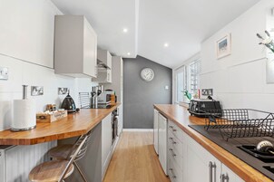 A compact kitchen with wooden countertops, a built-in oven, and a microwave.