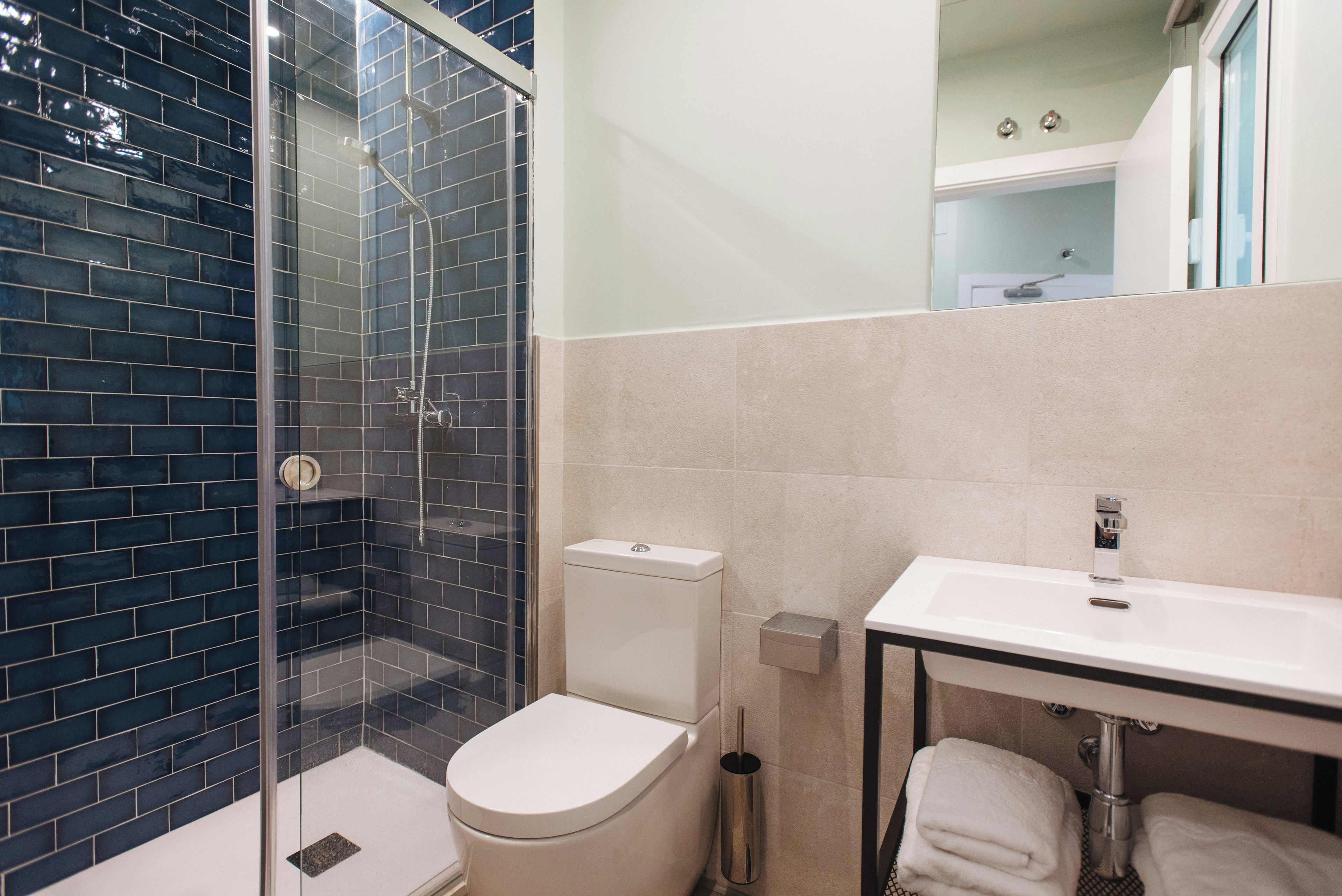 Ein Badezimmer mit Duschkabine, Toilette und Waschbecken mit Handtuch.