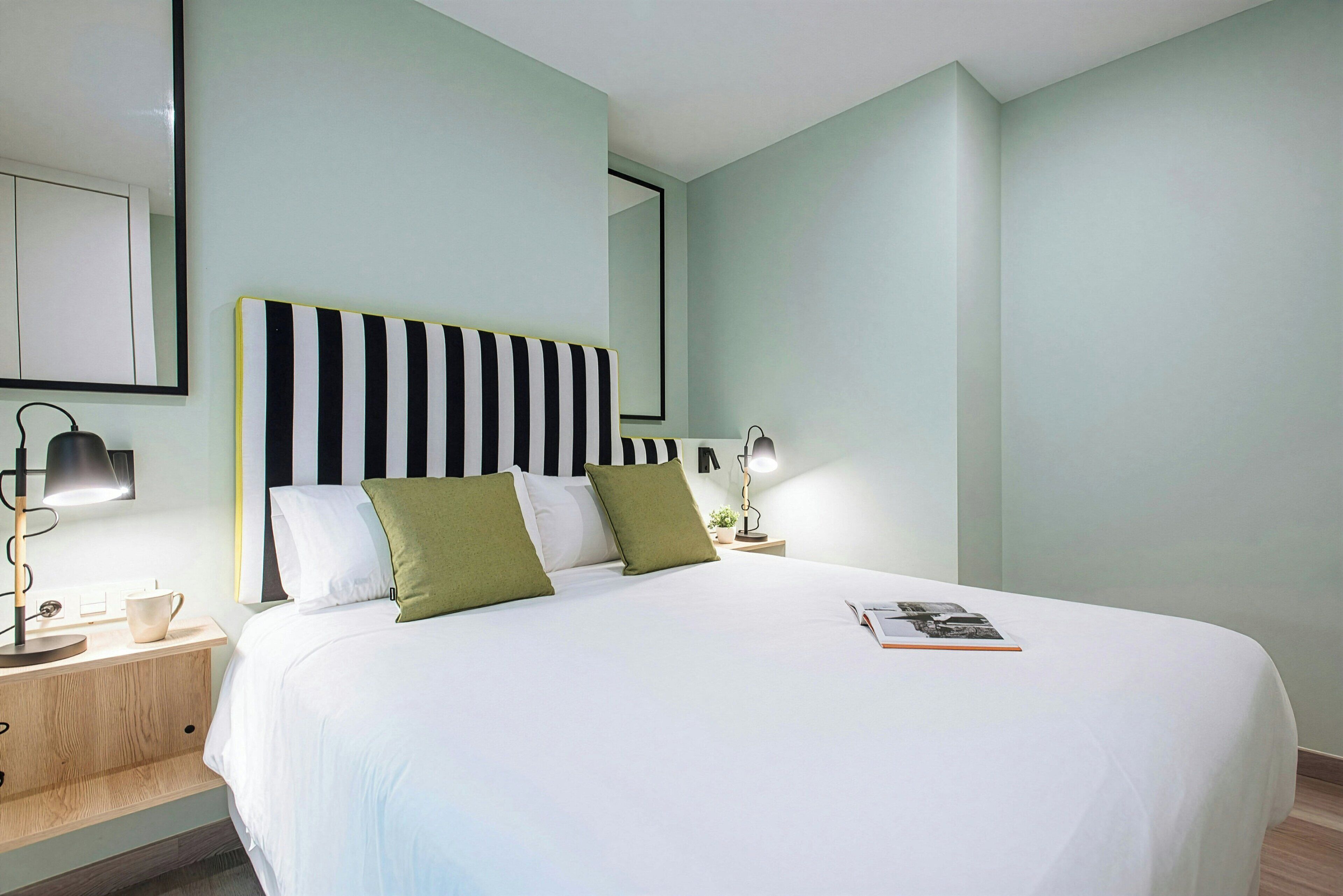 Una camera da letto moderna con un letto grande, due comodini e un tavolino da notte.
