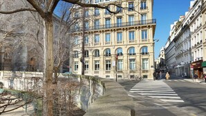 Een historisch gebouw met klassieke architectuur, een zebrapad en een heldere lucht.