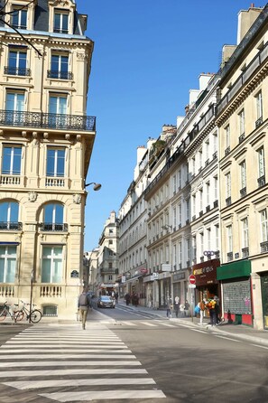Una vista di strada con edifici, un attraversamento pedonale e una bicicletta.
