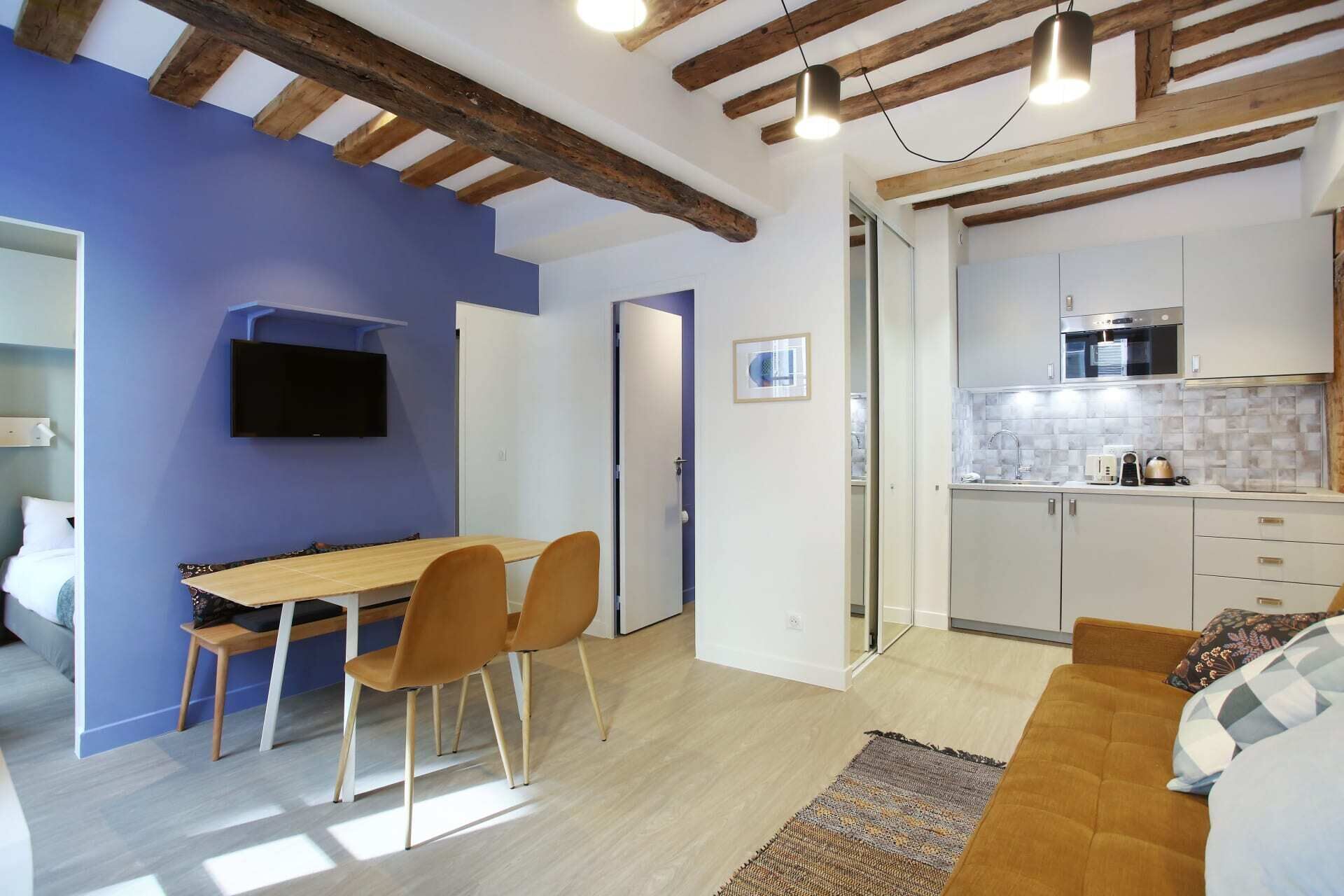 A modern interior with a dining area, kitchen, and seating space.
