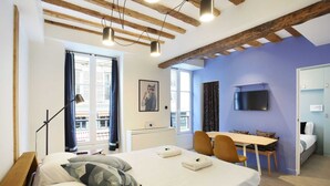 A modern bedroom with a bed, a desk, and a TV. - Cadet 104 - One Bedroom Apartment, Sleeps 4 (Paris)