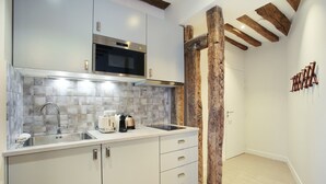 A modern kitchen with a stainless steel microwave, a built-in oven, a sink with a faucet, and a countertop with a toaster and a coffee maker. - Cadet 104 - One Bedroom Apartment, Sleeps 4 (Paris)