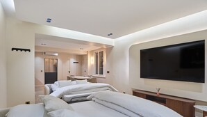 A modern hotel room with a large bed, a TV, and a dining area. - Caire 3 - One Bedroom Apartment, Sleeps 6 (Paris)
