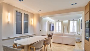 A modern interior with a dining area, sofa, and kitchen. - Caire 3 - One Bedroom Apartment, Sleeps 6 (Paris)