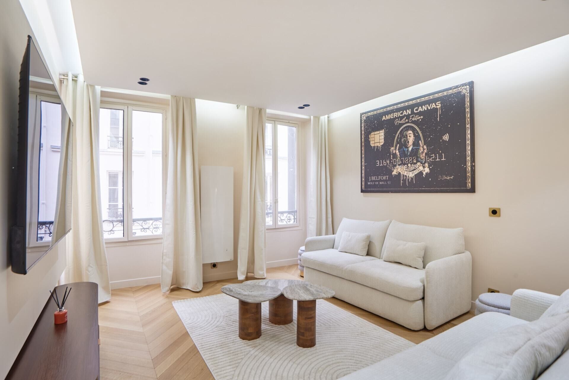 A living room with a sofa, a coffee table, and a wall-mounted artwork.