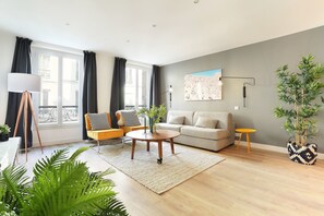 En moderne stue med sofa, sofabord og gulvlampe.