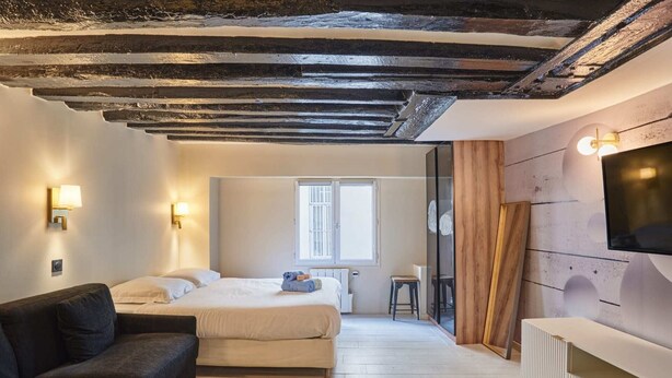 A bedroom with a bed, a sofa, a TV, and a window. - Chenier appart - Studio Apartment, Sleeps 4 (Paris)