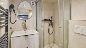 A modern bathroom with a glass-enclosed shower, a white sink, and a mirror. - Chenier appart - Studio Apartment, Sleeps 4 (Paris)