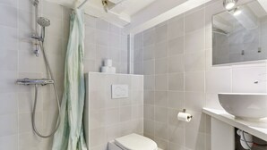 Un baño moderno con ducha, inodoro y lavamanos.