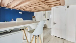 Una habitación con un escritorio blanco, una silla blanca, una pared azul y una puerta blanca.