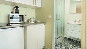 A modern kitchen with a microwave, sink, and cabinets. - Cosy Studio - Studio Apartment, Sleeps 2 (Paris)