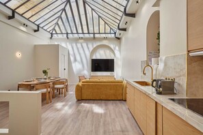 Una cocina moderna con tragaluz, armarios de madera y horno empotrado.