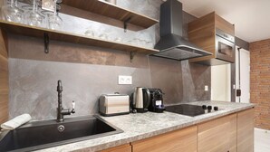 Una cocina moderna con horno empotrado, cafetera y tostadora.