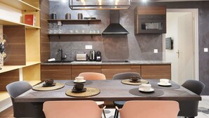 Una cocina moderna con una isla central, horno empotrado y una lámpara colgante.