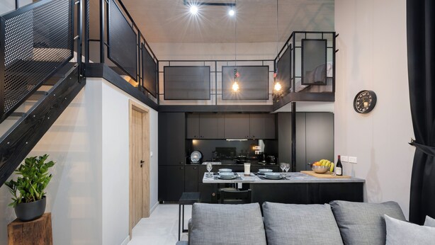 A modern kitchen with a dining area, a staircase, and a seating area with cushions. - 248 Boutique Studios (Sliema)