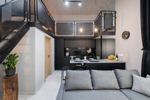 A modern kitchen with a dining area, a staircase, and a seating area with cushions. - 248 Boutique Studios (Sliema)