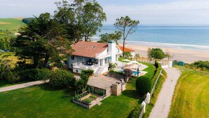A two-story house with a balcony overlooking a beach. - Wishome—A special villa to extend your summer at Oyambre Beach, Comillas (San Vicente de la Barquera)