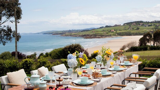 An outdoor dining area with a view of the beach and ocean. - Wishome—A special villa to extend your summer at Oyambre Beach, Comillas (San Vicente de la Barquera)