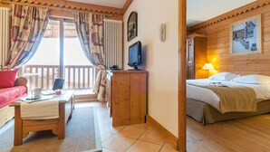 Una habitación acogedora con una cama, un escritorio y una ventana con cortinas.