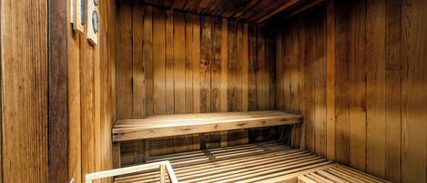A wooden sauna with benches and a bench with a towel rack.