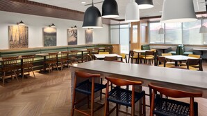 A restaurant with a long counter, booths, and high tables. - Fairfield Inn & Suites by Marriott Yankton (Yankton)