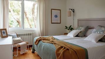 Un dormitorio con una cama grande, un escritorio y una ventana con cortinas.